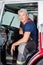 Confident Male Firefighter Sitting In Truck