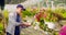 Confident male gardener examining potted flower plant
