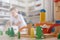 Confident male kid building fortress tower architecture wooden bricks ecology Montessori material