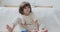 Confident male kid building multicolored wooden blocks sitting on floor at home