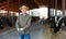 Confident man cow breeder standing in outdoor cowshed