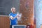 Confident man dusting powder by climbing wall in crossfit gym