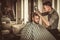 Confident man visiting hairstylist in barber shop.