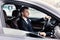 Confident man wearing suit and luxury watch driving car