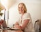 Confident mature woman sitting at working desk