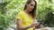 Confident mature woman using her smart phone sitting on a rock beside the river in the mountain.