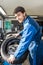 Confident Mechanic Mounting Car Tire On Rim In Garage