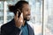 Confident millennial black businessman listen to record using smartphone loudspeaker