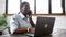 Confident multitasking African-American female office employee talking on the smartphone and typing