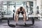 Confident muscular man training squats with barbells over head. Closeup portrait of professional man workout with barbell at gym.