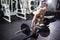 Confident muscular man training squats with barbells over head. Closeup portrait of professional man workout with barbell at gym.