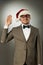 Confident nerd in Santa Claus hat and bow tie