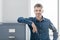 Confident office worker smiling and leaning on the filing cabinet