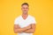 Confident and optimistic. Confident man with crossed arms yellow background. Happy guy smile with confidence. Confident