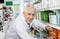 Confident Pharmacist Arranging Medicines On Shelf In Pharmacy