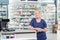 Confident Pharmacist Leaning At Cash Counter In