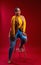 Confident plus size African woman posing on chair in studio