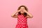 Confident portrait of gorgeous baby girl dressed in summer polka dots dress and straw hat , covering her eyes with her hands,