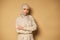 Confident portrait of serene and successful arabic Muslim woman posing with crossed arms on beige background with copy space