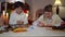 Confident positive boy and girl decorating Christmas cookies sitting at table in living room. Portrait of happy