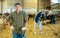 Confident positive farmer breeding dairy goats posing in shed