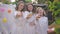 Confident pregnant mother and smiling daughters toasting apple juice looking at camera smiling celebrating baby shower