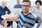 Confident professionals. Portrait of a young office worker sitting at a table with colleagues in the background.