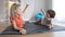 Confident relaxed Caucasian sister and brother raising fists up and looking at each other lying on exercise mats after