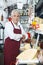 Confident Salesman Standing At Counter In Cheese Shop