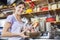 Confident Saleswoman Weighing Cheese At Grocery Store