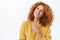 Confident, sassy pretty redhead caucasian woman with curly hair, wear winter yellow sweater, pointing left as make promo