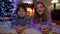 Confident satisfied boy and girl looking at camera smiling lying in cozy living room on New Year's eve at home