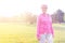 Confident senior athlete standing on grassy field in park