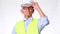 Confident senior engineering architect wearing vest and helmet on white background in studio.