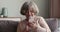 Confident senior grandma sit on sofa use phone work online