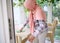 Confident serene Arab Muslim woman in home clothes and covered head in pink hijab wipes dust from the table on the veranda of the