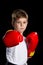 Confident serious boxer portrait. Straight attack kick in red boxing gloves