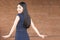 Confident and Smart Asian woman turning around with red brick wall interior.