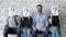 Confident smiling businessman sitting in row with unknown people