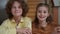 Confident smiling Caucasian boy and girl sitting at table smiling looking at camera. Zoom in zoom out portrait of happy