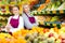 Confident smiling saleswoman standing with trainee salesgirl in greengrocery store