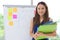 Confident smiling young Asian executive woman with document folder standing in office. Thoughtful and leadership business concept