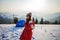 Confident solo asian woman traveller camping through an evergreen winter forest in Carpathians