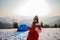 Confident solo asian woman traveller camping through an evergreen winter forest in Carpathians