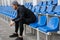 Confident sportsman sitting on tribune seats at the stadium