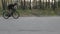 Confident strong fit cyclist sprinting out of the saddle. Side follow shot. Cycling concept. Slow motion