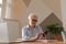 Confident stylish european middle aged senior woman using smartphone at workplace. Stylish older mature 60s gray haired