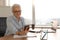 Confident stylish european middle aged senior woman using smartphone at workplace. Stylish older mature 60s gray haired