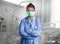 Confident and successful Asian Chinese medicine doctor woman in hospital scrubs and mask posing at clinic patient bed in