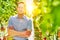 Confident supervisor standing with arms crossed againtst tomatoes growing in greenhouse